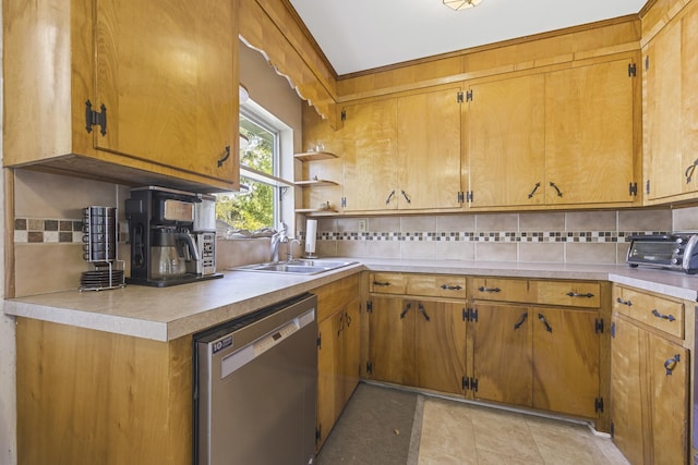 kitchen with decorative backsplash, dishwasher, light countertops, and a sink