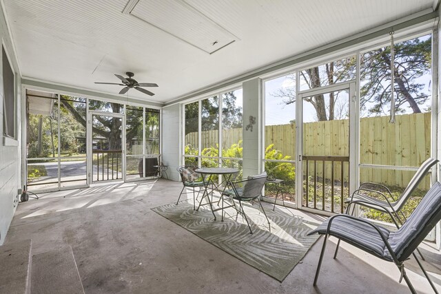 unfurnished sunroom with ceiling fan