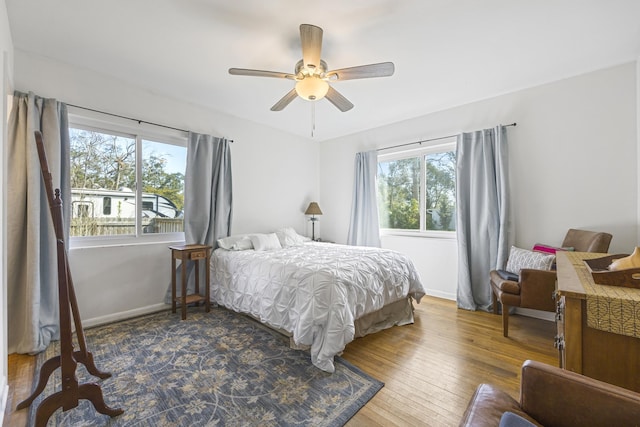 bedroom featuring ceiling fan, baseboards, and dark wood finished floors