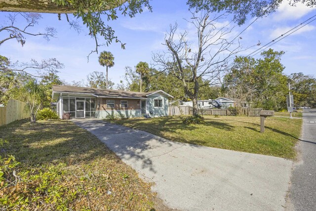 view of front of property with fence, a front lawn, and a sunroom