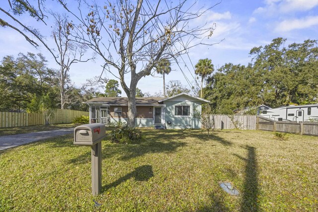 view of front of house featuring a front lawn and fence