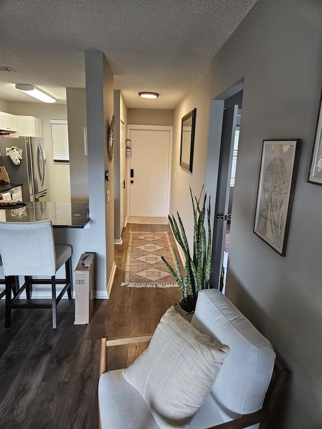 hallway featuring dark wood-type flooring and a textured ceiling