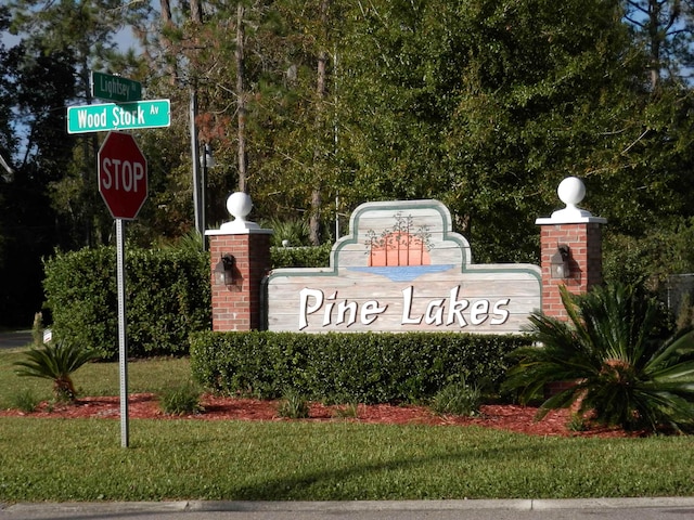 community / neighborhood sign featuring a yard