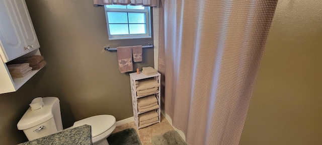 bathroom featuring a shower with shower curtain and toilet