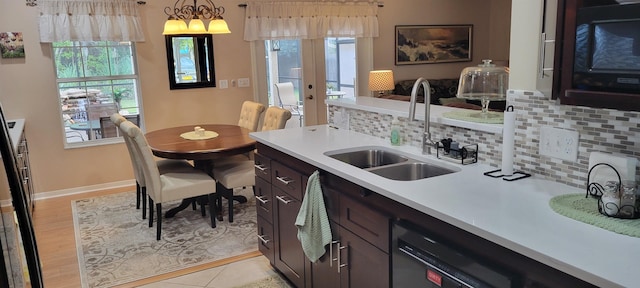 kitchen featuring plenty of natural light, dark brown cabinets, and sink