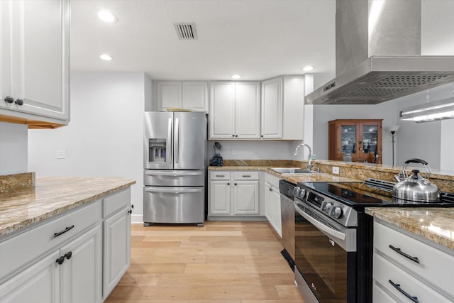 200 Raintree Trl, Saint Augustine, FL 32086 - kitchen with exhaust hood, appliances with stainless steel finishes, light wood finished floors, recessed lighting, and white cabinets