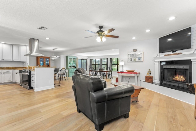 200 Raintree Trl, Saint Augustine, FL 32086 - living area with ceiling fan, a lit fireplace, light wood-style floors, recessed lighting, and bar area