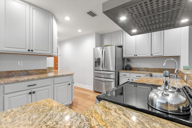 200 Raintree Trl, Saint Augustine, FL 32086 - kitchen with stainless steel fridge, light wood-style flooring, white cabinetry, and recessed lighting