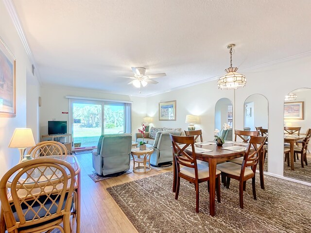 dining space featuring ceiling fan, wood-type flooring, and ornamental molding