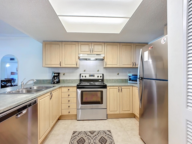 kitchen with appliances with stainless steel finishes, light tile patterned floors, light brown cabinetry, and sink