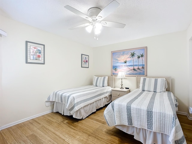 bedroom featuring ceiling fan, a textured ceiling, and light wood-type flooring