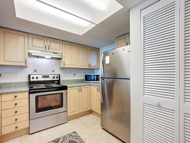 kitchen featuring decorative backsplash, a textured ceiling, stainless steel appliances, light brown cabinets, and light tile patterned floors