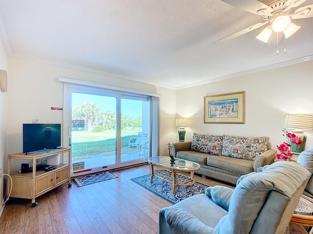 living room with crown molding, ceiling fan, wood-type flooring, and a textured ceiling