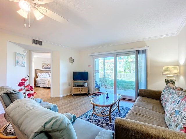 living room featuring light hardwood / wood-style flooring, ceiling fan, and ornamental molding