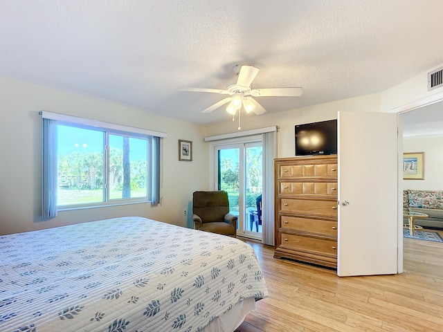 bedroom featuring access to exterior, ceiling fan, a textured ceiling, and light wood-type flooring