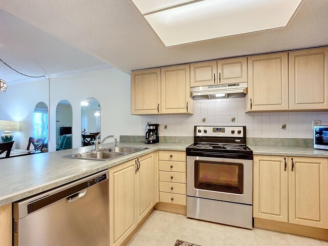 kitchen with decorative backsplash, appliances with stainless steel finishes, light brown cabinetry, sink, and light tile patterned floors