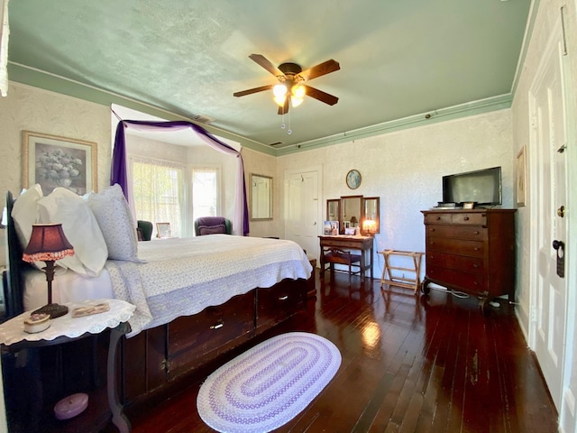 bedroom with crown molding, dark wood-type flooring, and ceiling fan