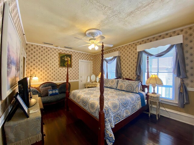 bedroom with ceiling fan, dark wood-type flooring, a textured ceiling, and crown molding