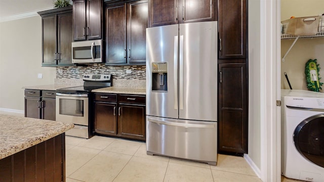 61 Grey Hawk Dr, Saint Augustine, FL 32092 - kitchen with appliances with stainless steel finishes, washer / clothes dryer, decorative backsplash, light tile patterned floors, and dark brown cabinetry
