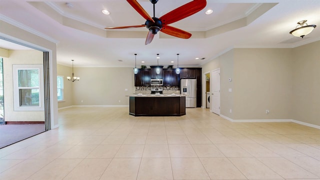 61 Grey Hawk Dr, Saint Augustine, FL 32092 - kitchen featuring appliances with stainless steel finishes, a tray ceiling, open floor plan, backsplash, and dark brown cabinetry