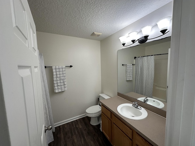 bathroom featuring toilet, hardwood / wood-style flooring, a textured ceiling, vanity, and curtained shower