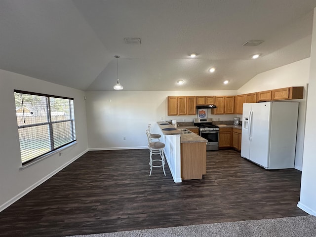 kitchen featuring decorative light fixtures, a kitchen breakfast bar, gas range, lofted ceiling, and white refrigerator with ice dispenser