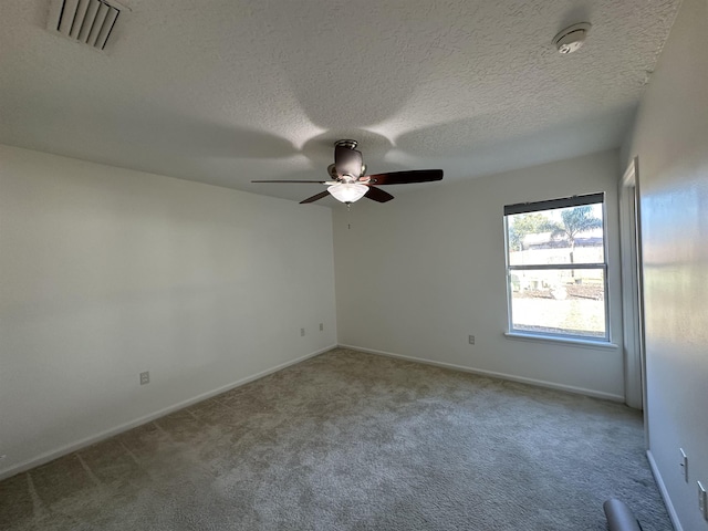 empty room featuring ceiling fan, carpet, and a textured ceiling