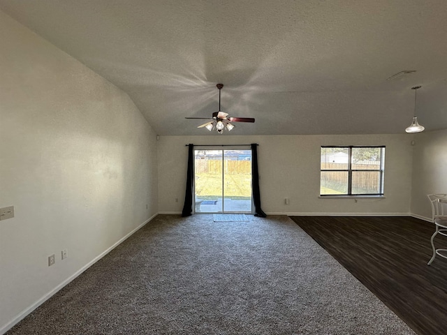 carpeted spare room with a textured ceiling, ceiling fan, lofted ceiling, and plenty of natural light