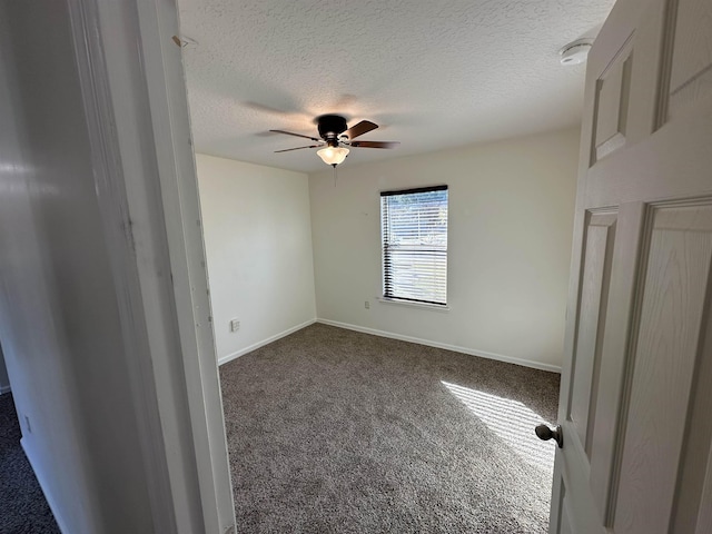 carpeted empty room with ceiling fan and a textured ceiling