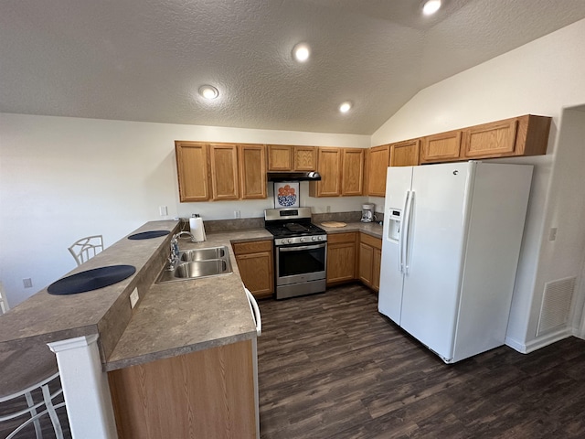 kitchen with lofted ceiling, stainless steel gas range oven, sink, white refrigerator with ice dispenser, and a textured ceiling