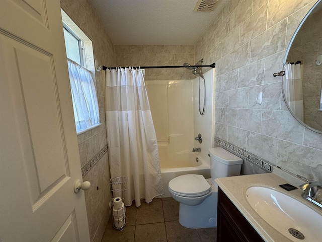 full bathroom with a healthy amount of sunlight, tile patterned flooring, tile walls, shower / bath combination with curtain, and vanity