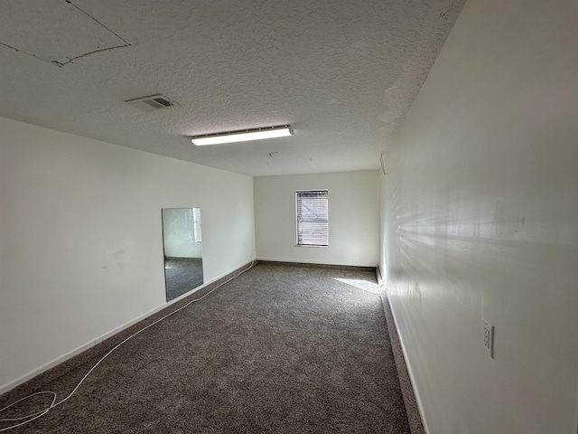 spare room featuring carpet floors and a textured ceiling