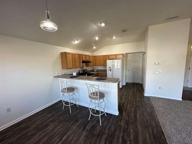 kitchen featuring white fridge with ice dispenser, decorative light fixtures, dark wood-type flooring, kitchen peninsula, and vaulted ceiling