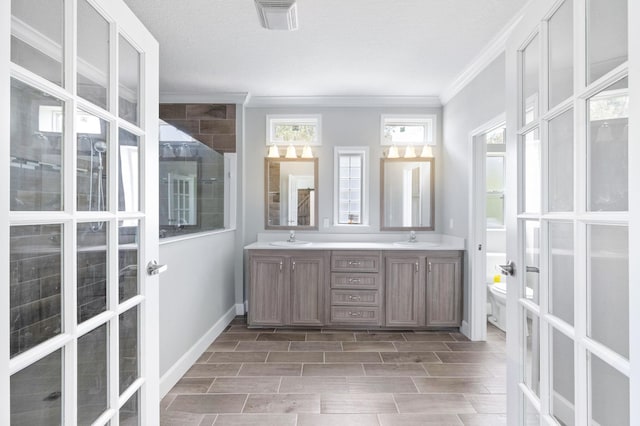 bathroom with ornamental molding, a textured ceiling, vanity, a shower, and toilet