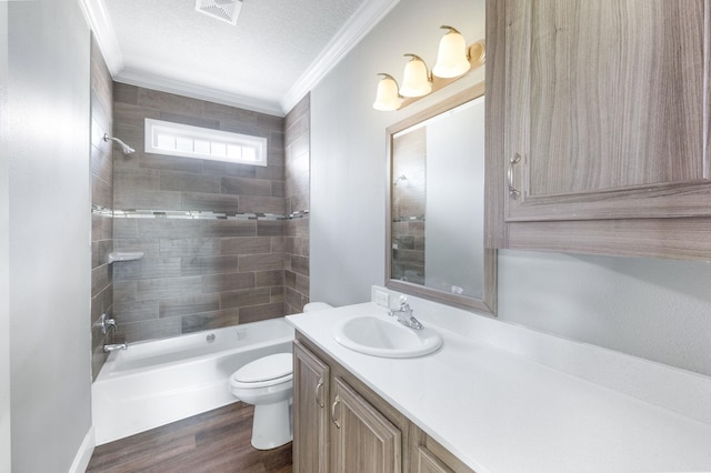 full bathroom with crown molding, tiled shower / bath, toilet, a textured ceiling, and wood-type flooring