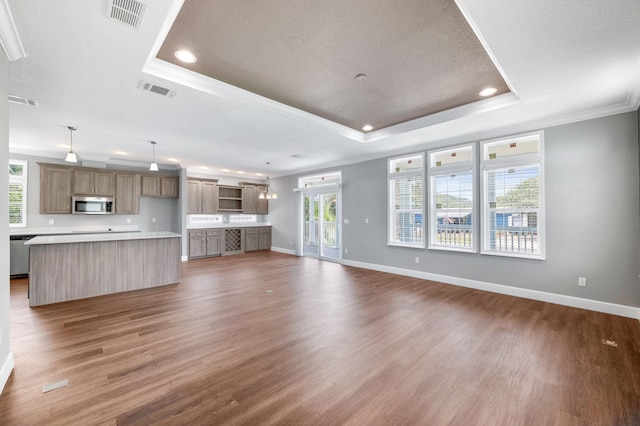 unfurnished living room featuring a textured ceiling, a raised ceiling, a wealth of natural light, and dark wood-type flooring