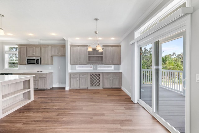 kitchen with hardwood / wood-style floors, decorative light fixtures, an inviting chandelier, and ornamental molding