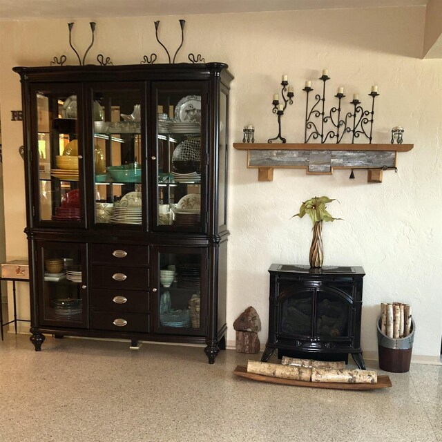 33 Camellia Dr, Ormond Beach, FL 32176 - bar with a wood stove, speckle patterned floor, and baseboards