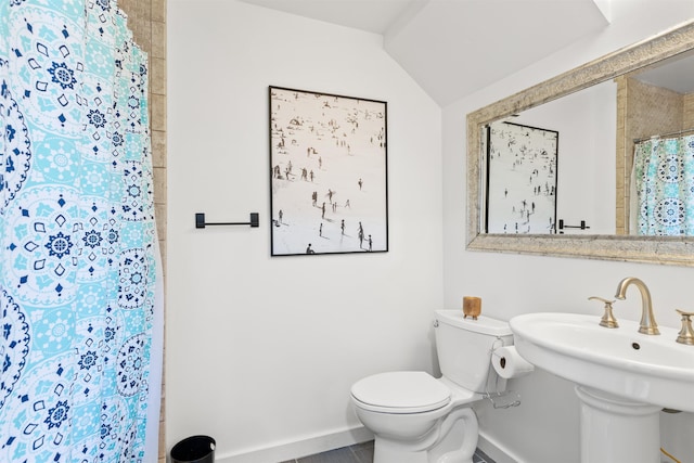 bathroom featuring a shower with curtain, lofted ceiling, sink, and toilet