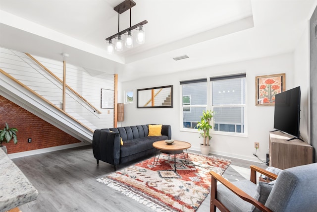 living room with dark hardwood / wood-style flooring and a tray ceiling