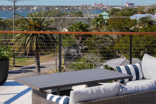 balcony with an outdoor living space and a water view