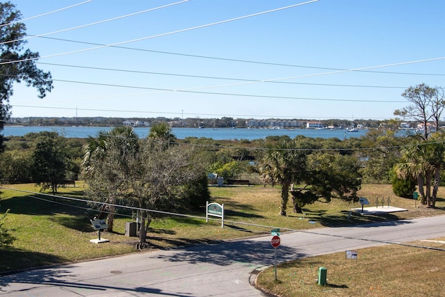 surrounding community with a lawn and a water view