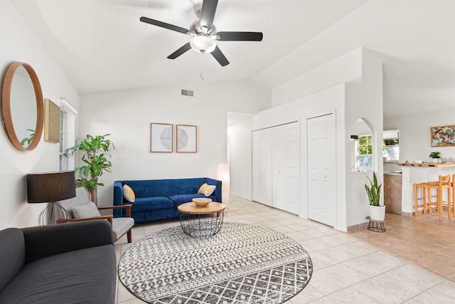 living room with light tile patterned flooring, ceiling fan, and vaulted ceiling