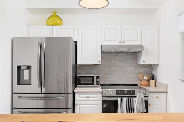 kitchen with stainless steel appliances, tasteful backsplash, and white cabinets