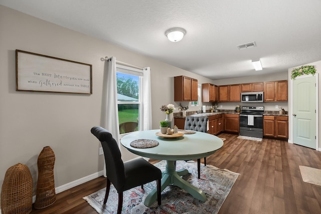 dining space with a textured ceiling and dark hardwood / wood-style floors