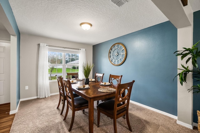 dining room with a textured ceiling and hardwood / wood-style flooring