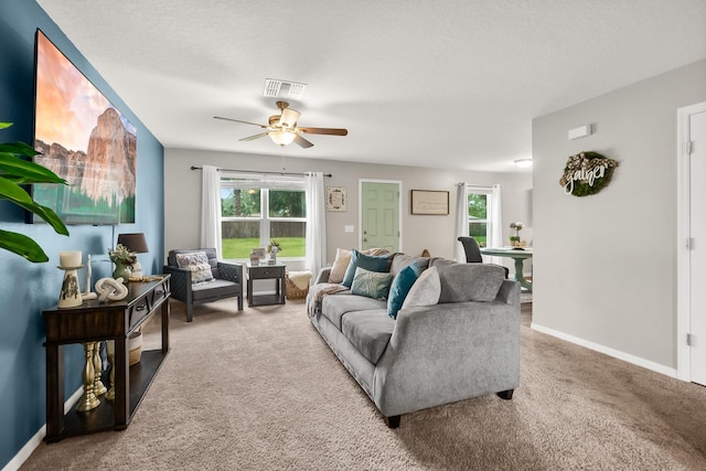 living room featuring carpet, ceiling fan, and a textured ceiling