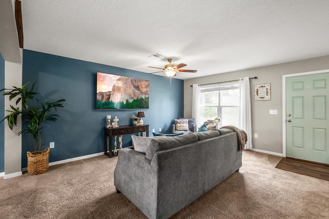 carpeted living room with a textured ceiling and ceiling fan