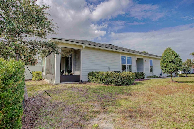 back of property with a sunroom and a yard