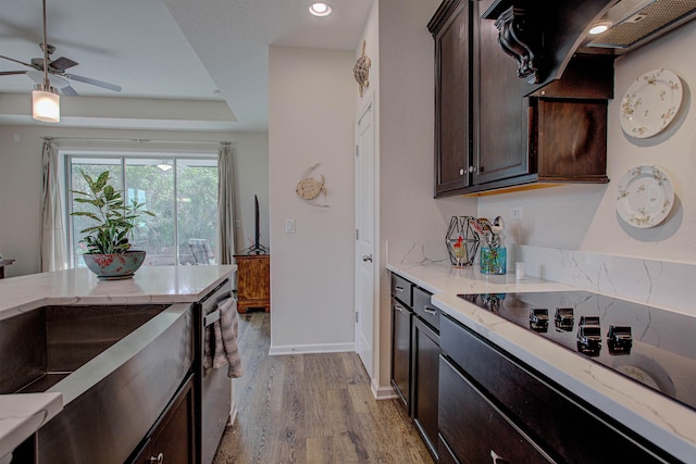 kitchen with dark brown cabinets, black electric cooktop, ventilation hood, ceiling fan, and light hardwood / wood-style floors